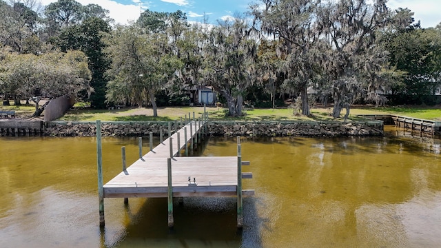 view of dock featuring a water view and a yard