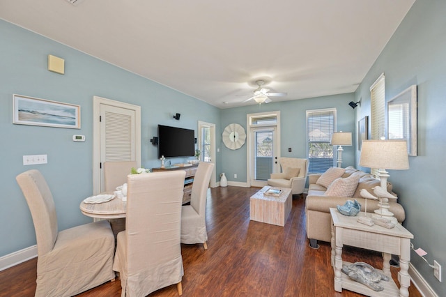 living room featuring ceiling fan, baseboards, and dark wood-style flooring