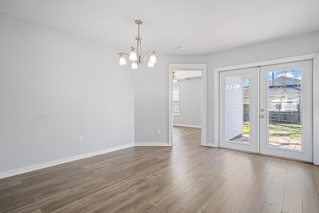 unfurnished dining area featuring french doors, a healthy amount of sunlight, and wood finished floors