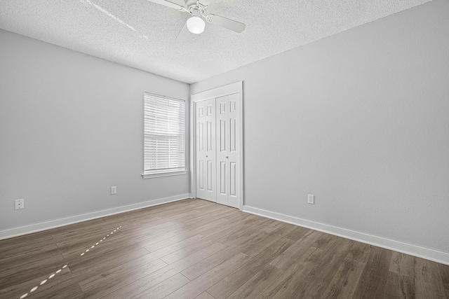 unfurnished room featuring a ceiling fan, a textured ceiling, baseboards, and wood finished floors