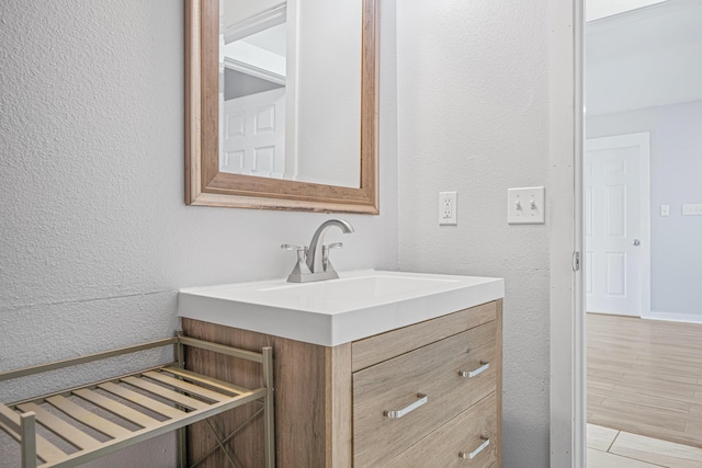 bathroom with a textured wall and vanity