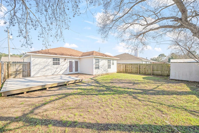 back of house featuring french doors, a fenced backyard, a lawn, and a deck