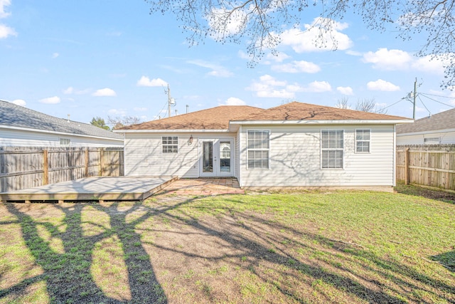 rear view of house featuring a deck, a yard, and a fenced backyard