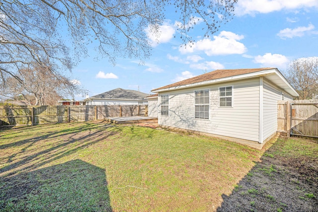 back of house featuring a lawn and a fenced backyard