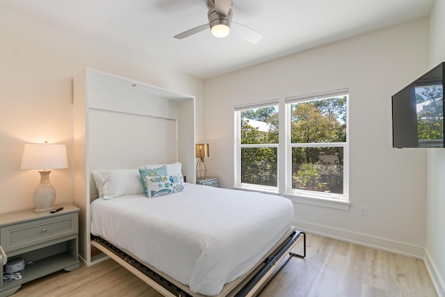 bedroom with light wood-style floors, baseboards, and a ceiling fan