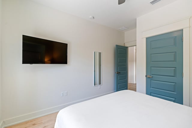 bedroom featuring light wood-style flooring, baseboards, ceiling fan, and a closet