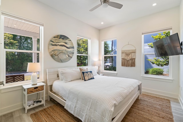 bedroom featuring multiple windows, baseboards, wood finished floors, and recessed lighting