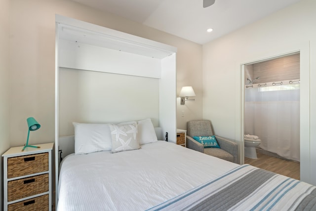 bedroom with ensuite bath, wood finished floors, and recessed lighting