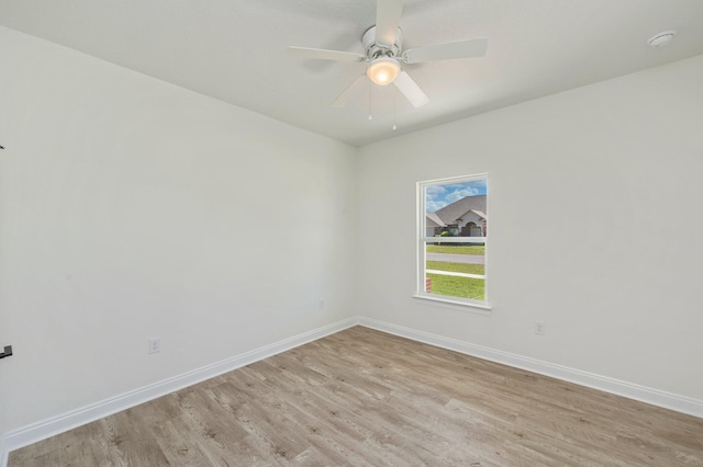 empty room with light wood-type flooring, a ceiling fan, and baseboards