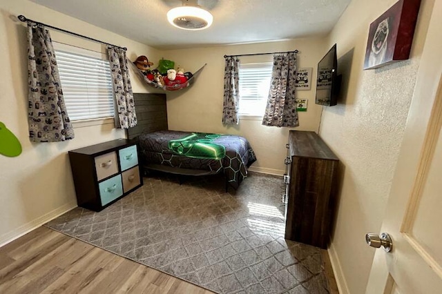 bedroom featuring baseboards and wood finished floors