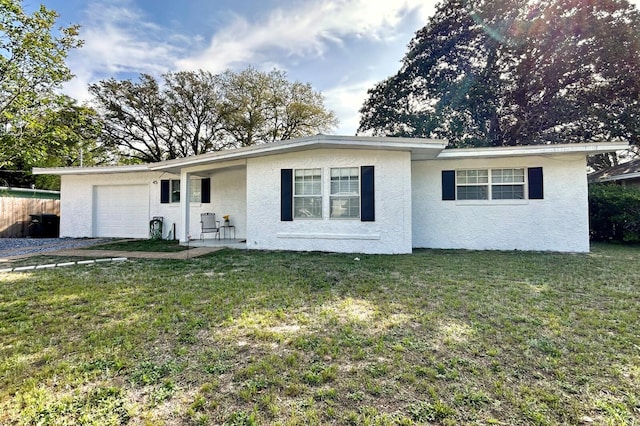 ranch-style home with a front lawn, stucco siding, and a garage