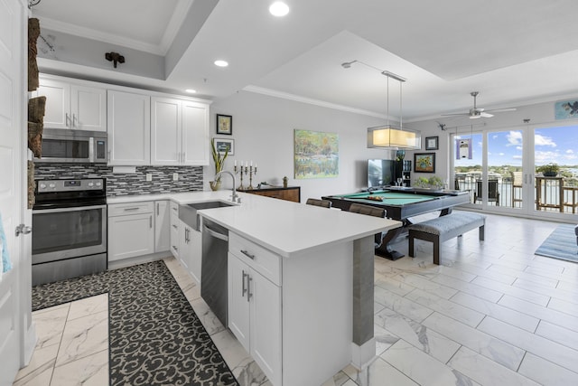 kitchen with marble finish floor, stainless steel appliances, a peninsula, and a sink