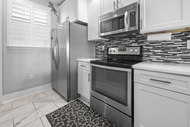 kitchen featuring marble finish floor, stainless steel appliances, decorative backsplash, and baseboards