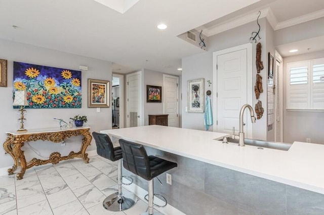 kitchen with visible vents, a kitchen breakfast bar, marble finish floor, a sink, and recessed lighting