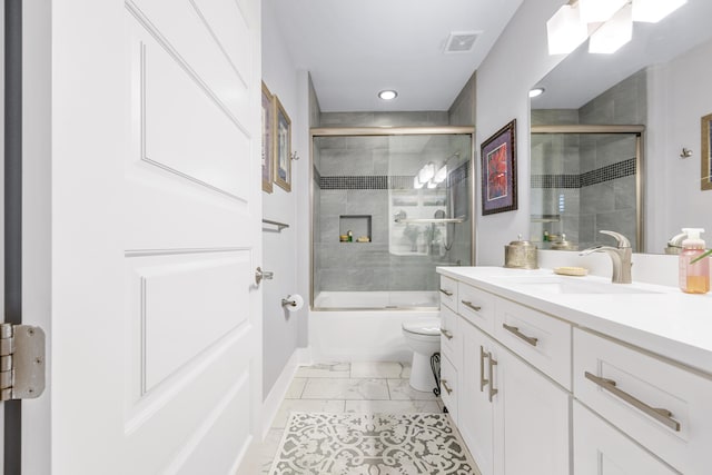 full bath featuring marble finish floor, bath / shower combo with glass door, visible vents, toilet, and vanity