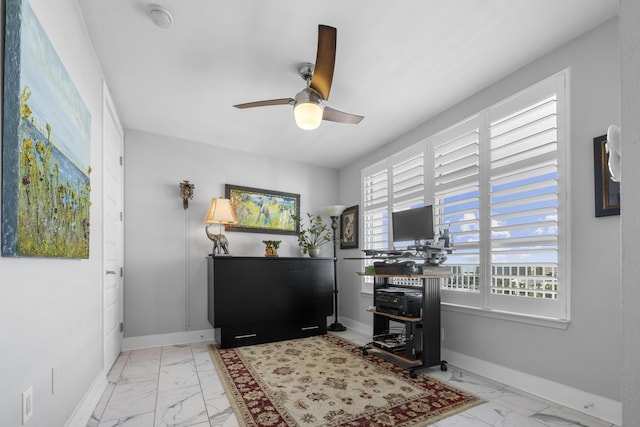 interior space featuring marble finish floor, ceiling fan, and baseboards