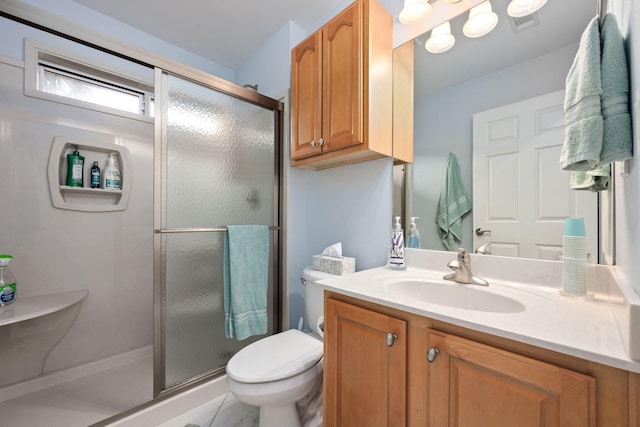 bathroom featuring visible vents, toilet, a shower stall, and vanity