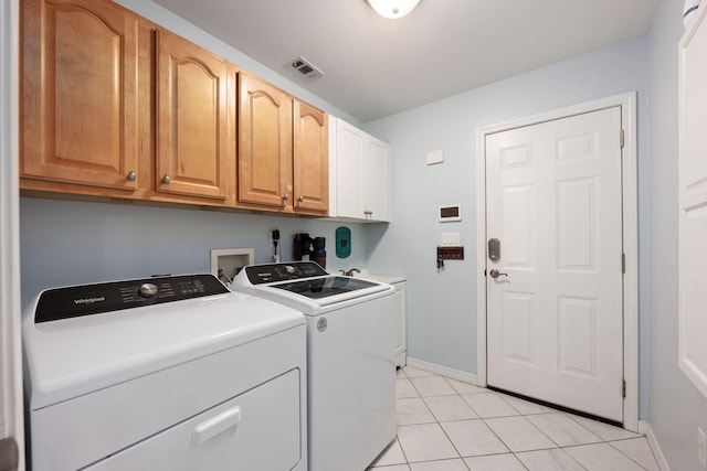 washroom with light tile patterned flooring, washing machine and dryer, visible vents, baseboards, and cabinet space