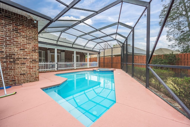 view of swimming pool featuring a pool with connected hot tub, a lanai, a fenced backyard, and a patio