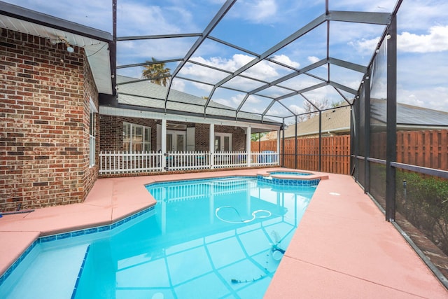 view of swimming pool featuring a patio, glass enclosure, a fenced backyard, ceiling fan, and a pool with connected hot tub