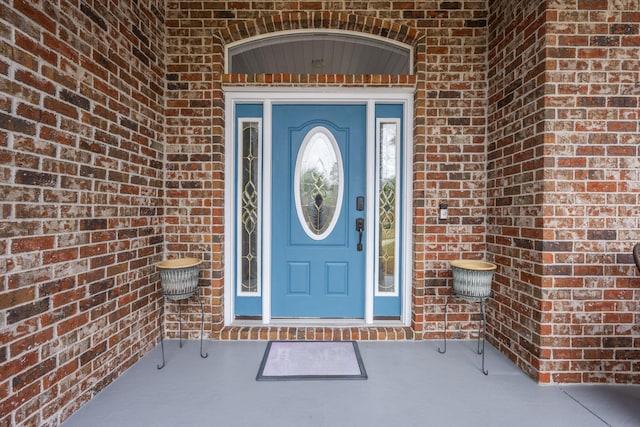 view of exterior entry with brick siding