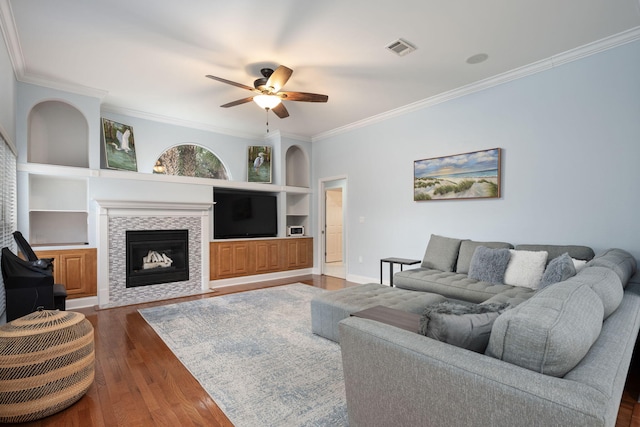 living area featuring ornamental molding, dark wood-style flooring, visible vents, and built in features