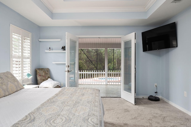 bedroom featuring access to outside, french doors, multiple windows, and a tray ceiling