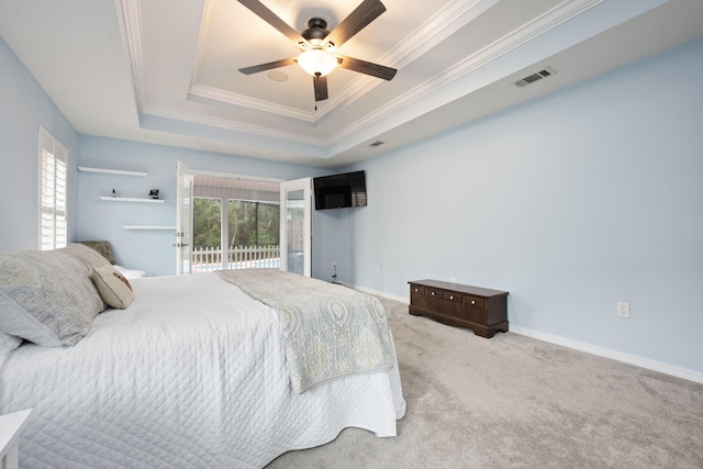 carpeted bedroom featuring multiple windows, visible vents, a raised ceiling, and crown molding