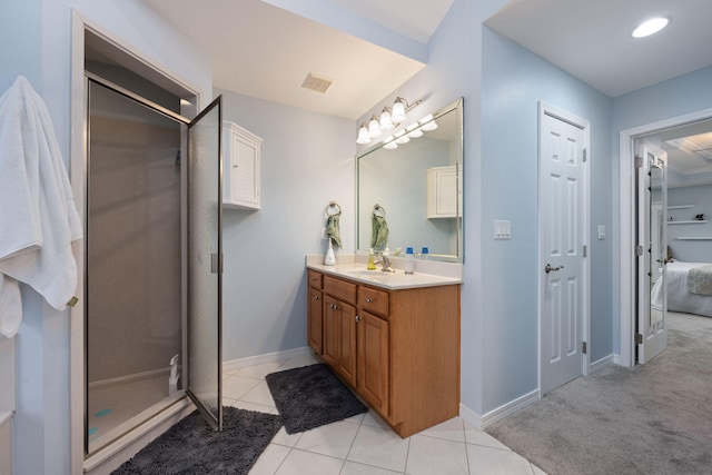 bathroom with tile patterned flooring, vanity, visible vents, baseboards, and a stall shower