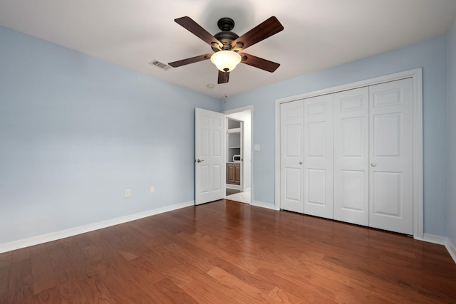 unfurnished bedroom with baseboards, visible vents, and dark wood finished floors