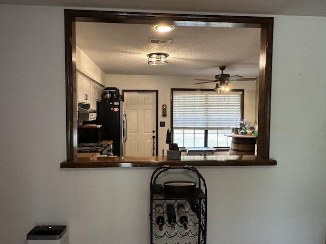 223 W Pinoak Ct, Crestview, FL 32539 - kitchen with freestanding refrigerator, ceiling fan, dark countertops, extractor fan, and a textured ceiling
