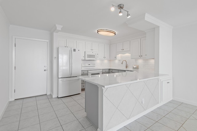 kitchen with a peninsula, white appliances, white cabinets, and light tile patterned flooring