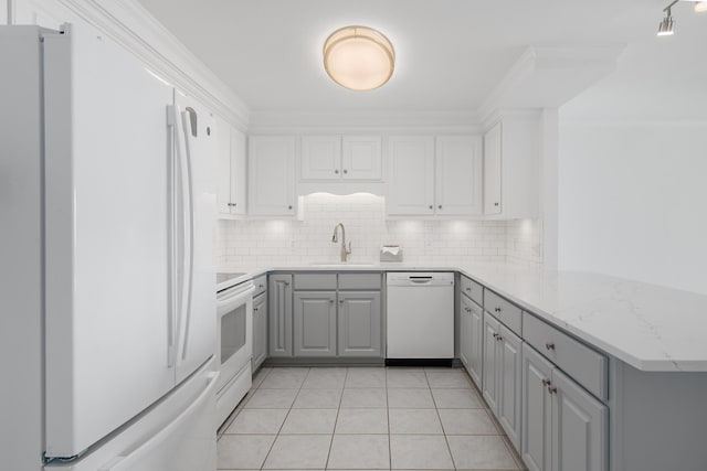 kitchen with white appliances, a sink, a peninsula, and backsplash