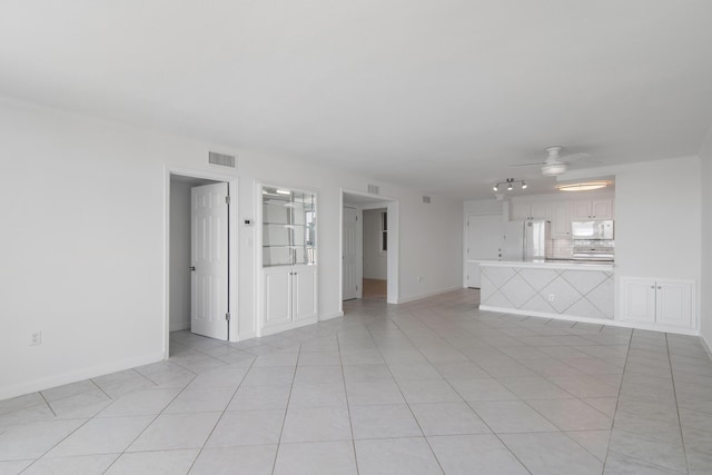 unfurnished living room with baseboards, visible vents, a ceiling fan, and light tile patterned flooring