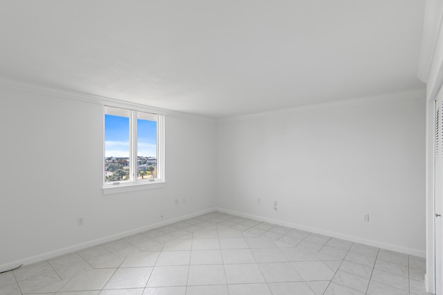 spare room featuring light tile patterned floors, baseboards, and crown molding