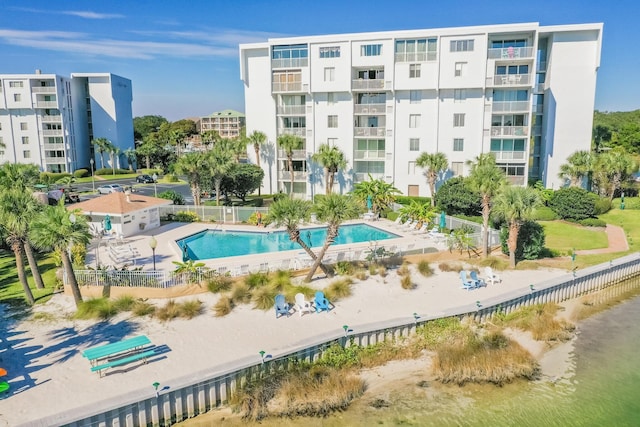 community pool with a water view and fence