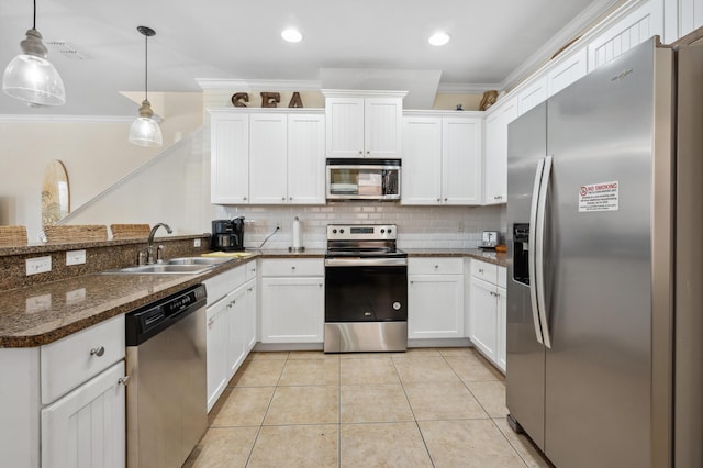 kitchen featuring white cabinetry, appliances with stainless steel finishes, and decorative light fixtures