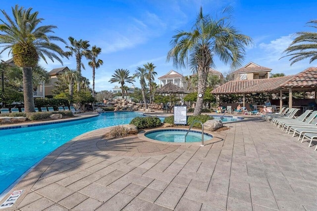 community pool with a community hot tub, a patio, and a gazebo