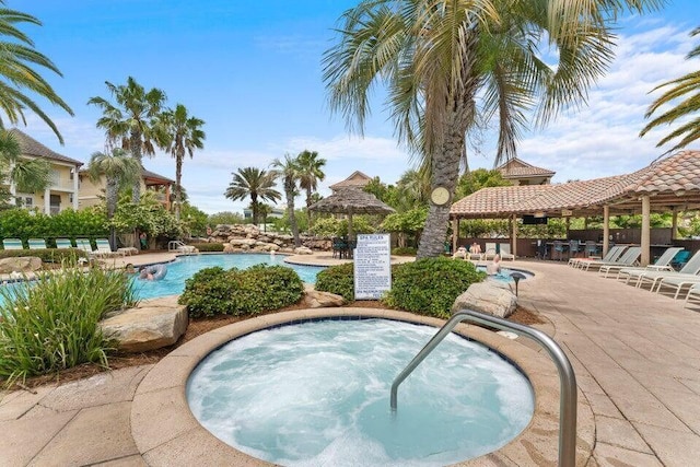 pool featuring a patio area, a hot tub, and a gazebo