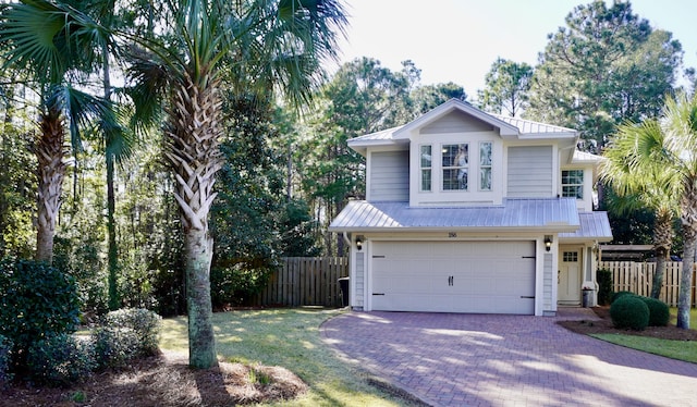 view of front of property with a garage, decorative driveway, metal roof, and fence