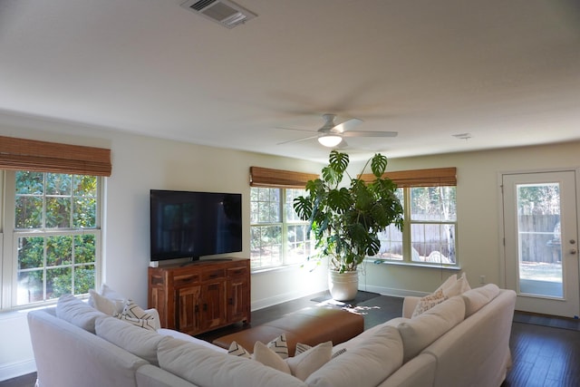 living room featuring ceiling fan, dark wood-type flooring, visible vents, and baseboards