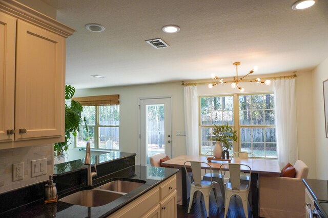 kitchen featuring a chandelier, recessed lighting, a sink, visible vents, and dark stone counters