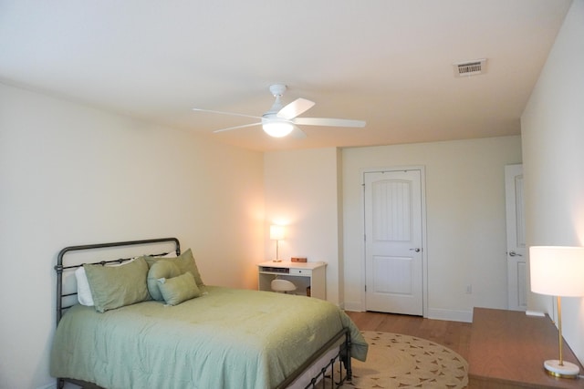 bedroom with baseboards, light wood-style flooring, visible vents, and a ceiling fan