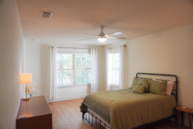 bedroom featuring ceiling fan, wood finished floors, and visible vents