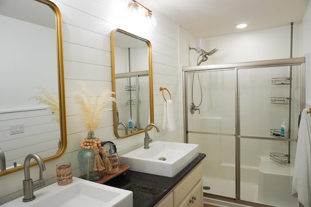 full bathroom with wooden walls, a sink, and a shower stall