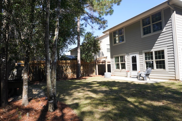 rear view of property with a lawn, a patio area, and fence