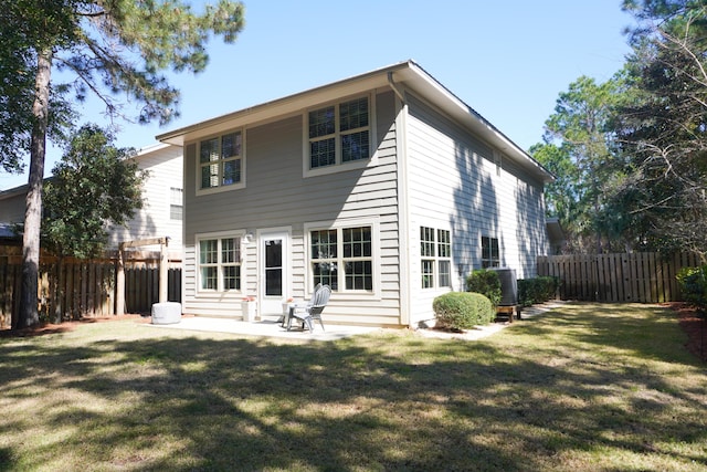 back of house featuring fence private yard, a patio area, and a lawn