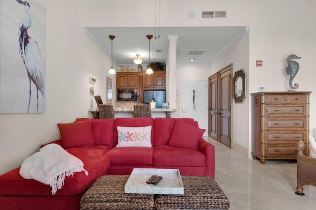 living area with ornamental molding, visible vents, and baseboards