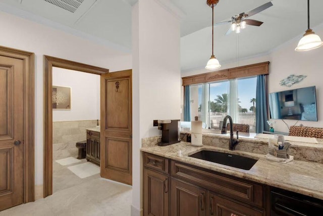 kitchen featuring visible vents, dishwasher, light stone counters, hanging light fixtures, and a sink