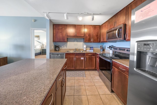 kitchen with stainless steel appliances, a sink, and light tile patterned flooring